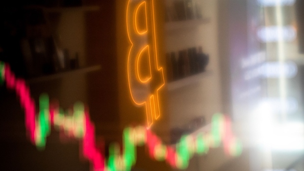 A reflection of a candlestick price chart and an illuminated Bitcoin logo inside a BitBase cryptocurrency exchange in Barcelona, Spain, on Monday, May 16, 2022. The wipeout of algorithmic stablecoin TerraUSD and its sister token Luna knocked more than $270 billion off the crypto sector’s total trillion-dollar value in the most volatile week for Bitcoin trading in at least two years. Photographer: Angel Garcia/Bloomberg