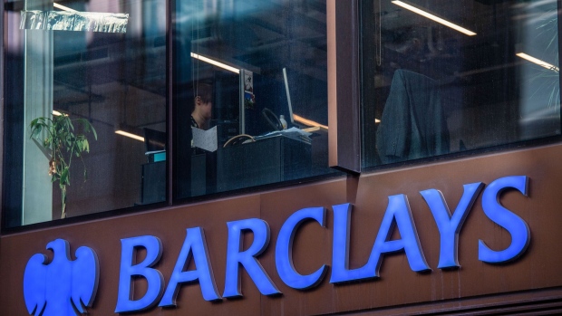 An office worker sits at her desk above a Barclays Plc bank branch in the City of London, U.K., on Tuesday, April 26 2022. Barclays is one of the banks along with, HSBC Holdings Plc Lloyds Banking Group Plc and NatWest Group Plc reporting earning this week.