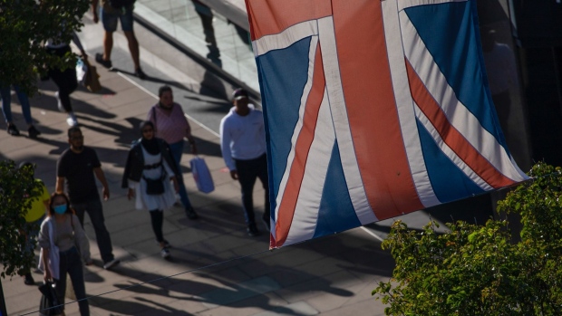 A British Union Flag, also known as a Union Jack, hangs above pedestrians walking on Oxford Street in central London, U.K., on Thursday, Sep. 17, 2020. U.K. retail sales extended their recovery in August as a government initiative to boost the hospitality industry lured locked-down Britons out to the shops. Photographer: Simon Dawson/Bloomberg