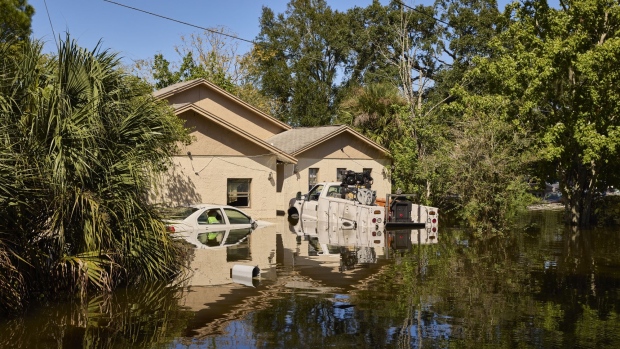 Vehicles and a home submerged in water in a flooded neighborhood following Hurricane Ian in Orlando, Florida, US, on Friday, Sept. 30, 2022. Two million electricity customers in Florida remained without power Friday morning, according to the tracking site poweroutage.us. Photographer: Brian Carlson/Bloomberg