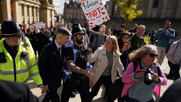Jacob Rees-Mogg surrounded by police, walks through protestors in Victoria square as he arrives on the first day of the Conservative Party Conference at the ICC in Birmingham, England, on Oct. 2, 2022.