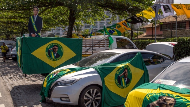Flags supporting Jair Bolsonaro, Brazil's president, displayed on vehicles during the first round of presidential elections in the Barra da Tijuca neighborhood of Rio de Janeiro, Brazil, on Sunday, Oct. 2, 2022. Brazilians head to the polls to choose between re-electing Bolsonaro or returning former President Luiz Inacio Lula da Silva to office.