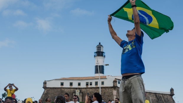 A supporter of Jair Bolsonaro, Brazil's president, waves a Brazilian flag at a rally during Bahia's Independence Day in Salvador, Bahia state, Brazil, on Saturday, July 2, 2022. Former leftist president Luiz Inacio Lula da Silva still leads the Brazilian presidential race in a potential runoff against incumbent Bolsonaro, a survey carried out between June 20-24 by Futura for Modalmais shows. Photographer: Maira Erlich/Bloomberg