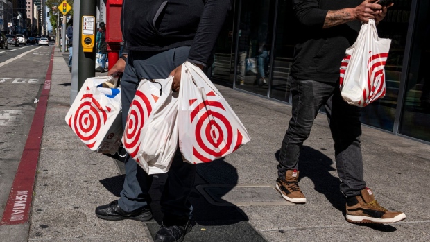 Shoppers carry Target shopping bags in front of a store in San Francisco, California, US, on Tuesday, May 10, 2022. Target Corp. is scheduled to release earnings figures on May 18.