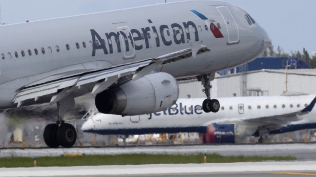 FORT LAUDERDALE, FLORIDA - JULY 16: An American Airlines plane lands on a runway near a parked JetBlue plane at the Fort Lauderdale-Hollywood International Airport on July 16, 2020 in Fort Lauderdale, Florida. JetBlue Airways and American Airlines Group announced they will be creating an alliance between the two companies. (Photo by Joe Raedle/Getty Images) Photographer: Joe Raedle/Getty Images North America