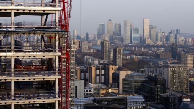 Skyscrapers in the Canary Wharf business, shopping and financial district on the skyline beyond a construction site in the City of London, U.K., on Monday, March 21, 2022. The U.K. is expanding the Financial Conduct Authority’s powers in a package of post-Brexit changes to the way it regulates the City of London. Photographer: Chris Ratcliffe/Bloomberg