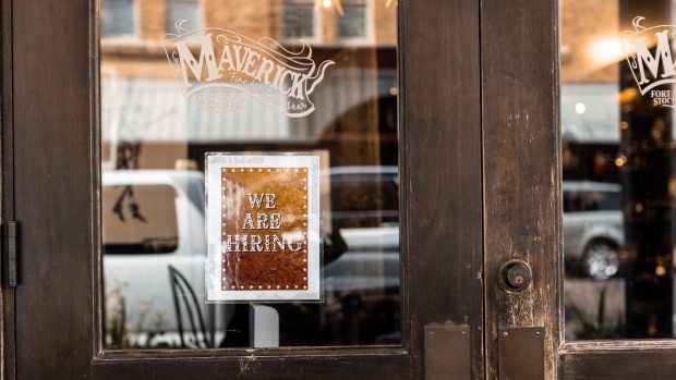 A "We are Hiring" sign the front doors to Maveric Western Wear at the Fort Worth Stockyards in Fort Worth, Texas, U.S., on Monday, April 12, 2021. The U.S. economy is on a multi-speed track as minorities in some cities find themselves left behind by the overall boom in hiring, according to a Bloomberg analysis of about a dozen metro areas. Photographer: Kathy Tran/Bloomberg