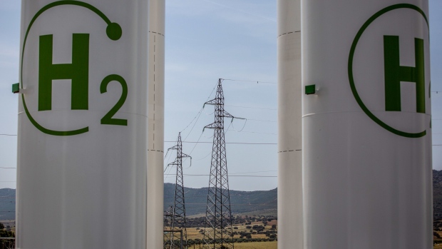 High voltage electricity transmission towers beyond hydrogen storage tanks during the final stages of construction at Iberdola SA's Puertollano green hydrogen plant in Puertollano, Spain, on Thursday, May 19, 2022. The new plant will be Europe's largest production site for green hydrogen for industrial use. Photographer: Angel Garcia/Bloomberg