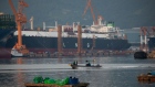 A fishing boat sails past liquefied natural gas (LNG) tankers under construction at the Daewoo Shipbuilding & Marine Engineering Co. shipyard in Geoje, South Korea, on Friday, June 5, 2020. Qatar has signed a deal worth around $20 billion with South Korean shipbuilders to help cement its position as the world’s largest producer of liquefied natural gas. Photographer: SeongJoon Cho/Bloomberg