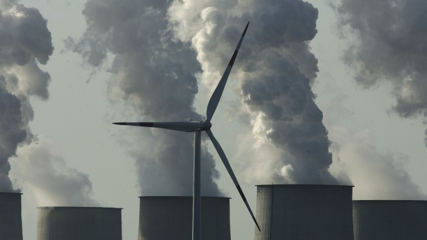 COTTBUS, GERMANY - APRIL 12: A loan wind turbine spins as exhaust plumes from cooling towers at the Jaenschwalde lignite coal-fired power station, which is owned by Vatenfall, April 12, 2007 at Jaenschwalde, Germany. Germany is planning the construction of 40 new coal-fired power plants, though officials claim the plants are based on technology that radically increases their efficiency. The Jaenschwalde power plant, built by the former East German government in the 1980s, emits 25 million tons of CO2 annually and is among the biggest single producers of CO2 emissions in Europe. (Photo by Sean Gallup/Getty Images)