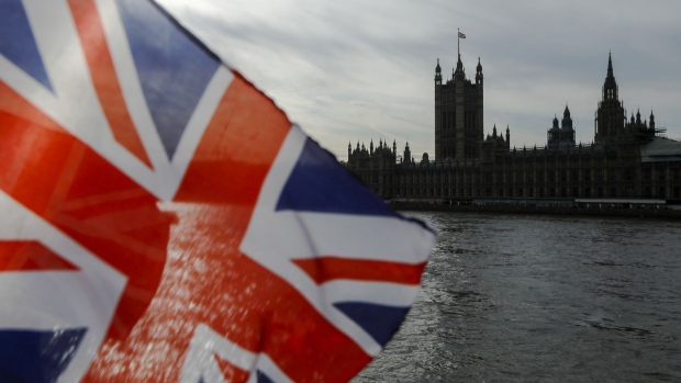 A British Union flag, also known as a Union Jack, flies from a tourist souvenir stall on the bank of the River Thames in view of the Houses of Parliament in London, U.K., on Wednesday, Oct. 30, 2019. U.K. Prime Minister Boris Johnson has succeeded, finally, in getting Parliament to give him the general election that he wants. Photographer: Luke MacGregor/Bloomberg