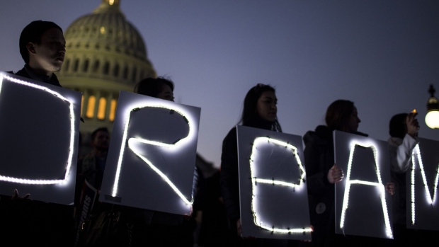 Demonstrators hold illuminated signs during a rally supporting the Deferred Action for Childhood Arrivals program (DACA), or the Dream Act, outside the U.S. Capitol building in Washington, D.C., U.S., on Thursday, Jan. 18, 2018. The House passed a spending bill Thursday to avoid a U.S. government shutdown, but Senate Democrats say they have the votes to block the measure in a bid to force Republicans and President Donald Trump to include protection for young immigrants. Photographer: Zach Gibson/Bloomberg