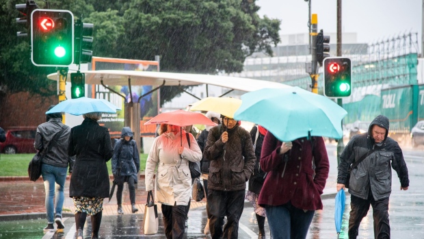 Pedestrians use umbrellas while walking along a sidewalk in Wellington, New Zealand, on Thursday, June 18, 2020. New Zealand entered recession for the first time in almost a decade as the coronavirus pandemic led to the nation’s biggest quarterly contraction in 29 years. Photographer: Mark Coote/Bloomberg