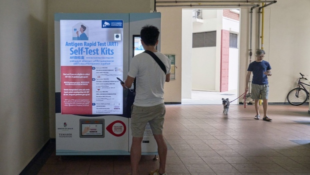 A person navigates a touch screen monitor to receive a free COVID-19 antigen rapid test (ART) kit from the government on a vending machine in Redhill in Singapore, on Saturday, July 9, 2022. Singapore is scheduled to announce its second quarter advanced gross domestic product (GDP) estimate on July 14, 2022.