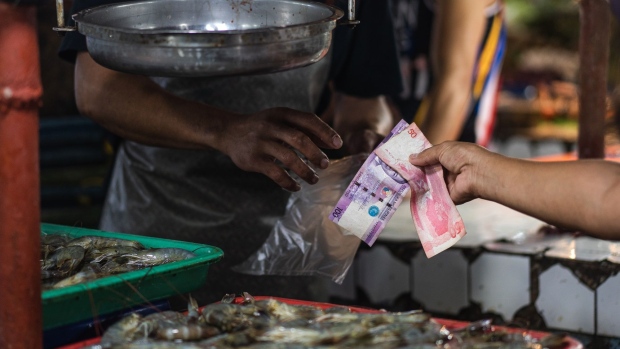 A shopper hands Philippines' Peso banknotes for payment at a market in Mandaluyong, the Philippines, on Monday, Sept. 5, 2022. Philippines inflation rate rose 6.3% from a year earlier in August, the Philippine Statistics Authority said in a statement on its website. Photographer: Iya Forbes/Bloomberg
