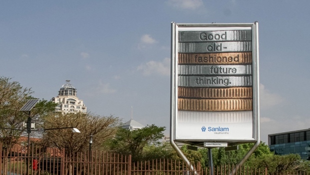 A pedestrian passes an advertisement for Sanlam Ltd. financial services group on a roadside in central Sandton, South Africa. Photographer: Dean Hutton/Bloomberg