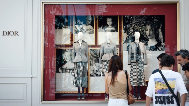 A shopper browses the window display of a Christian Dior SE luxury store on Avenue Montaigne in Paris, France, on Sunday, July 24, 2022. French President Emmanuel Macron's government passed its first big test in the freshly elected National Assembly with the approval of measures aimed at sheltering households from the shock of surging inflation.