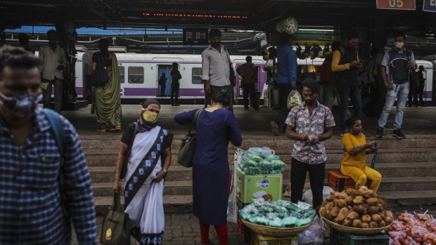 Commuters walk past a street vendor outside the Dadar railway station during a weekend lockdown in Mumbai, India, on Saturday, April 10, 2021. Maharashtra has halted all non-essential services, ordered private companies to work from home, and shut malls and restaurants through April. Photographer: Dhiraj Singh/Bloomberg