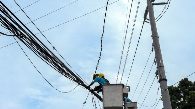 Manila Electric Co. (Meralco) workers repair damaged power lines in Quezon City, Metro Manila, the Philippines, on Thursday, July 28, 2022. The Philippines gets about 57% of its electricity from coal, burning the equivalent of 29 million tons of high quality fuel, according to data from BloombergNEF and BP Plc. Photographer: Veejay Villafranca/Bloomberg