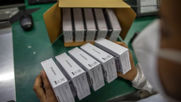 A worker boxes phones on an assembly line at the Lava International Ltd. factory in Noida, Uttar Pradesh, India, on Tuesday, Sept. 22, 2020. Under the Production Linked Incentive program, or PLI as it’s called, manufacturing incentives will rise each year in an ongoing effort to entice the world’s biggest smartphone brands to make their products in India and export to the world. Photographer: Prashanth Vishwanathan/Bloomberg