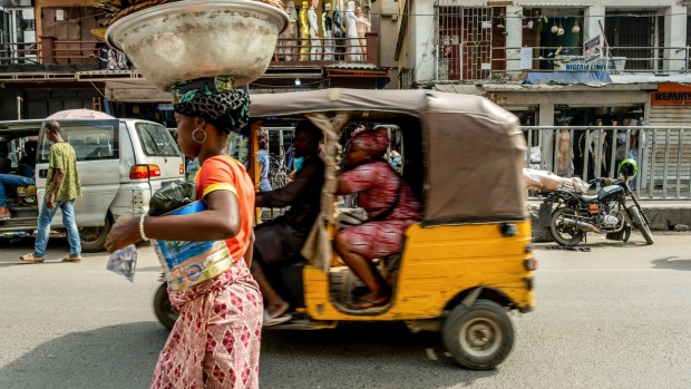 A street trader and auto rickshaw in Lagos.