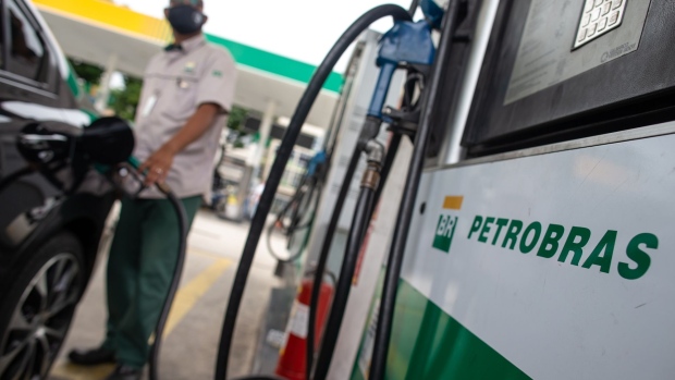 A worker fuels a vehicle at a Petroleo Brasileiro SA (Petrobras) gas station in Rio de Janeiro, Brazil, on Friday, Feb. 19, 2021. Petrobras declined after President Jair Bolsonaro said that the company's fuel price increases have been excessive, undermining the company's efforts to dispel concerns about political interference.