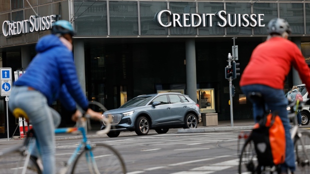 Commuters cycle past a Credit Suisse Group AG bank branch in Basel, Switzerland, on Tuesday, Oct. 25, 2022. Credit Suisse will present its third quarter earnings and strategy review on Oct. 27.