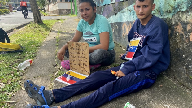 Yulexny Gonzalez, left, and Rolando Suarez left Venezuela on Aug. 20, crossed the Darien Gap and are now stuck in Costa Rica. They are selling lollipops on the streets of San Jose, Costa Rica to earn enough money for rent and basic goods.
