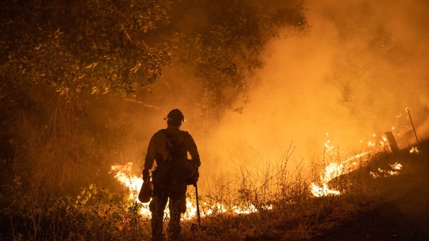 A firefighter holds a drip torch along Michigan Bluff Road during the Mosquito Fire near Foresthill, California, US, on Wednesday, Sept. 7, 2022. A wildfire burning in the Tahoe National Forest exploded Wednesday afternoon prompting evacuation orders near Foresthill.