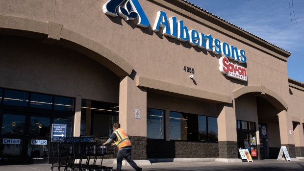 A worker pushes shopping carts outside an Albertsons supermarket in Las Vegas, Nevada, U.S., on Friday, Jan. 7, 2022. Albertsons Cos is scheduled to release earnings figures on January 11.