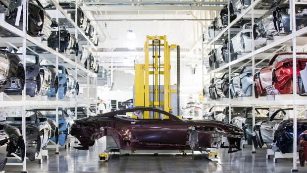 A robot on transports the body of an Aston Martin DBS Superleggera automobile on the production line at the Aston Martin Lagonda Ltd. manufacturing and assembly plant in Gaydon, U.K., on Tuesday, Sept. 4, 2018. Aston Martin is preparing to list its shares in London after the brand synonymous with U.K. spymaster James Bond pulled off a multi-year turnaround. Photographer: Chris Ratcliffe/Bloomberg