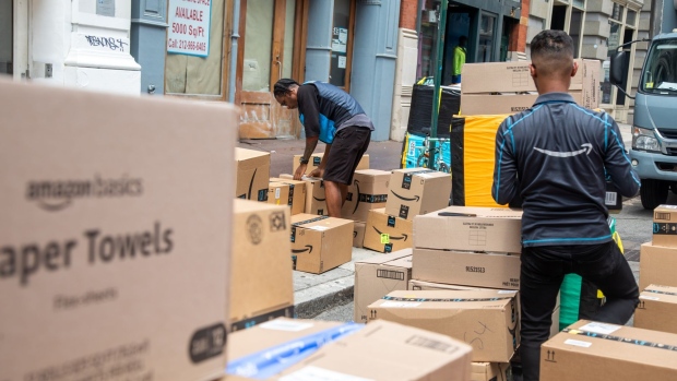Workers sort packages to be delivered on Amazon Prime Day in New York, US, on Tuesday, July 12, 2022. Bargain hunters are expected to find Amazon.com Inc.'s two-day Prime Day sale underwhelming this year, with many sellers minimizing profit-eating discounts in an era of soaring costs.