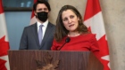 Chrystia Freeland and Justin Trudeau speak during a news conference in Ottawa on Jan. 26, 2022.