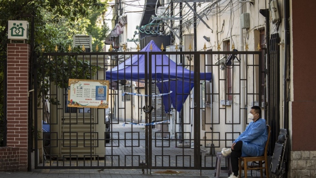 A guard at the entrance to a neighborhood under lockdown in Shanghai. Photographer: Qilai Shen/Bloomberg
