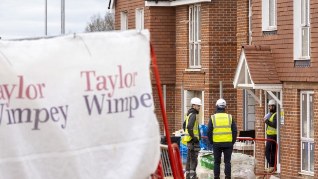 Builders on a Taylor Wimpey Plc residential housing construction site in Surrey, U.K. on Tuesday, Feb. 8, 2022. The housing market has defied the plight of the wider economy since the pandemic began, boosted by temporary tax incentives, a shortage of stock and demand for properties outside urban areas with room to work from home.