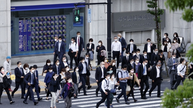 Pedestrians in front of a branch of Mizuho Securities Co., a unit of Mizuho Financial Group Inc., in Tokyo, Japan, on Monday, April 25, 2022. Mizuho Securities is scheduled to release earnings figures on April 28. Photographer: Kiyoshi Ota/Bloomberg