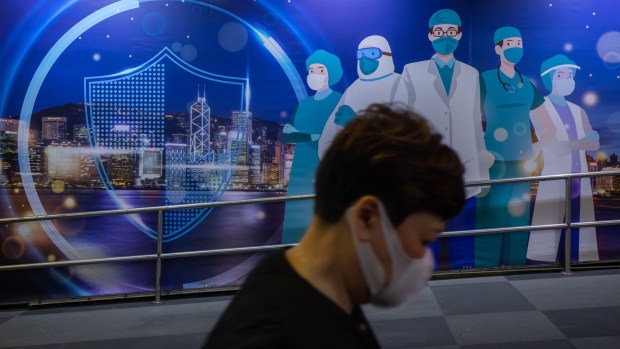 A pedestrian walks past an mural featuring healthcare workers in Hong Kong, China, on Friday, Feb. 18, 2022. Hong Kong is considering stricter social-distancing measures and preparing for a universal testing push to try to curtail an escalating virus outbreak thats straining its health infrastructure.