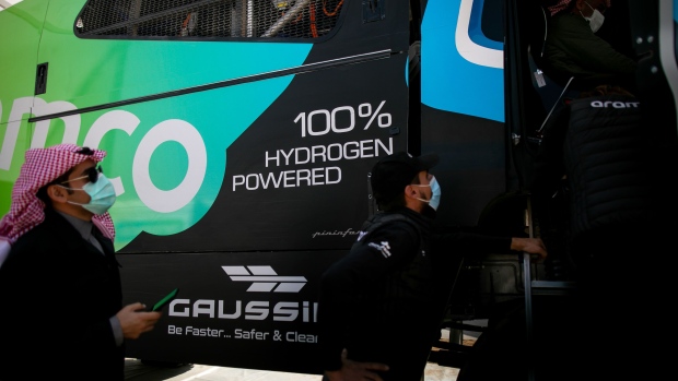 Visitors inspect the Saudi Aramco H2 hydrogen-powered racing truck, developed by Gaussin, during the Dakar Rally in Riyadh, Saudi Arabia, on Saturday, Jan. 8, 2022. State-controlled oil producer Saudi Aramco sponsored the first hydrogen fueled truck to compete in the Dakar Rally, which takes place in Saudi Arabia Jan. 2-14.