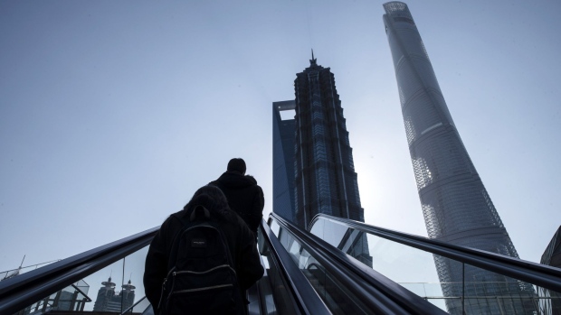 Pedestrians ride on an escalator in Pudong's Lujiazui Financial District in Shanghai, China, on Thursday, Feb. 18, 2021. China's stock benchmark erased gains after briefly surpassing its 2007 closing peak, as mainland financial markets opened for the first time following the Lunar New Year break. Photographer: Qilai Shen/Bloomberg
