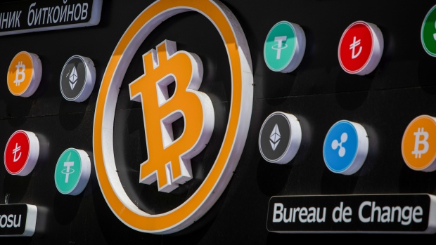 A bitcoin, center, and other cryptocurrency logo signs outside a cryptocurrency exchange kiosk in Istanbul, Turkey, on Tuesday, April 26, 2022. Both tech stocks and Bitcoin have notched big swings this year as the Federal Reserve becomes less accommodative as part of its fight to combat inflation. Photographer: Erhan Demirtas/Bloomberg