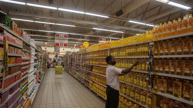 A Shoprite worker arranges cooking oil on shelves in Lilongwe, Malawi, March 16, 2022. Photographer: Amos Gumulira/Getty Images