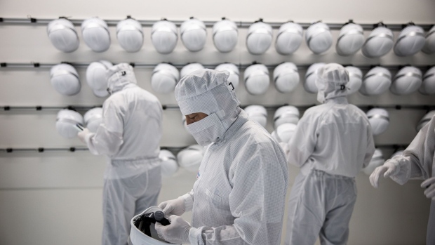 Employees put on safety helmets as they prepare to enter a clean room during semiconductor wafer manufacture inside the new Infineon Technologies AG 300 millimetre thin wafer chip factory in Villach, Austria, on Thursday, Sept. 16, 2021. Infineon Chief Executive Officer Reinhard Ploss said the fully automated factory is expected to generate revenue of €2 billion per year.