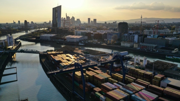 Shipping containers on a barge at Frankfurt Osthafen container port dock near skyscrapers on the financial district skyline, in the financial district in Frankfurt, Germany, on Tuesday, April 20, 2021. Financial markets around the world are waking up to the risks of another coronavirus flare-up. Photographer: Alex Kraus/Bloomberg