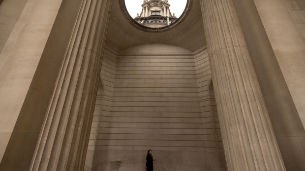 A commuter passes through arches of the Bank of England (BOE) in the City of London, UK, on Monday, Oct. 17, 2022. The Bank of England said it was restarting its corporate bond-selling as it looks to return to normality in the wake of a sustained selloff in UK assets.