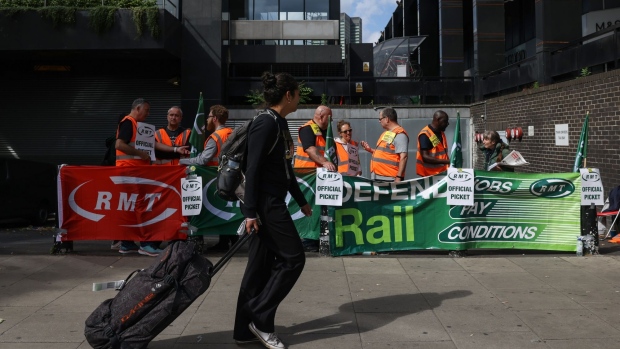 A traveler passes a picket line at Euston station in London, in June.