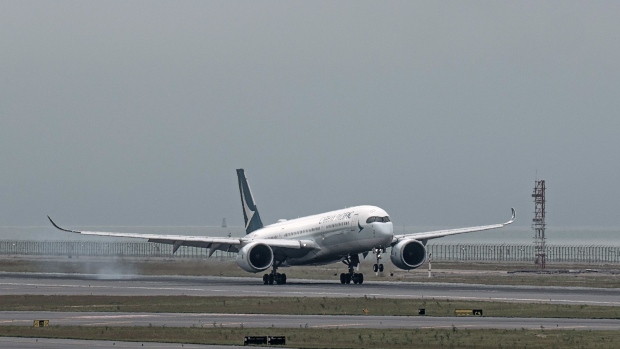 An aircraft operated by Cathay Pacific Airways Ltd. lands on the third runway at Hong Kong International Airport in Hong Kong, China, on Friday, Nov. 25, 2022. Hong Kong's new, third runway, which opened in July, is part of a HK$141.5 billion ($18 billion) project that will increase its footprint by 50%, adding 650 hectares (1,606 acres), equivalent to the size of Gibraltar.