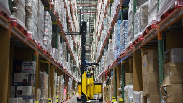 A worker uses a forklift to remove a pallet of goods from a storage rack in an aisle at the Amazon Inc. fulfillment center in Bengaluru, India, on Tuesday, Sept. 18, 2018. India, with its more than 1.3 billion people, has become a fierce battleground for Amazon.com Inc., and the company has committed some $5.5 billion to building up its network there.