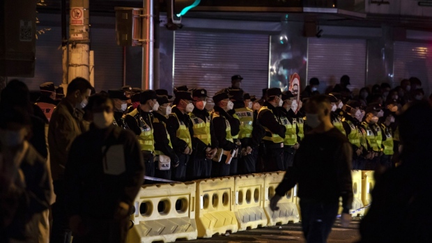 Police officers stand guard during a protest in Shanghai, China, on Sunday, Nov. 27, 2022.  Source: Bloomberg