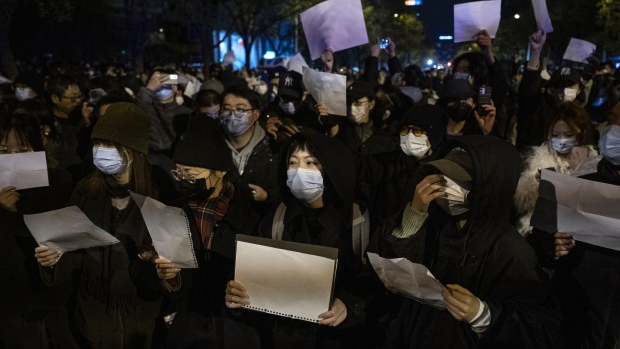 Protesters hold up blank pieces of paper during a protest in Beijing on Nov. 27.