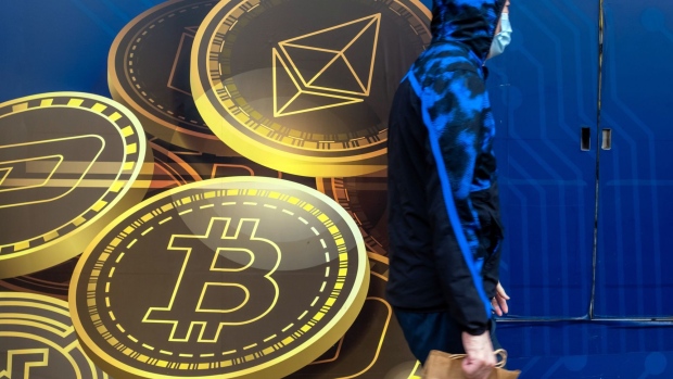 A pedestrian walks past signage for Ethereum, top, and Bitcoin outside the Hong Kong Digital Asset Exchange Ltd. digital currency trading store in Hong Kong, China, on Thursday, June 24, 2021. Hong Kong Digital Asset Exchange is a cryptocurrency platform and is the first to combine online and physical exchange in Hong Kong.